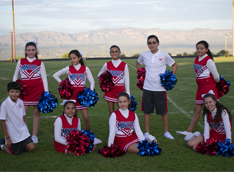 Cheerleaders pose together outside