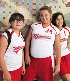 Female students in Miner sports attire pose together